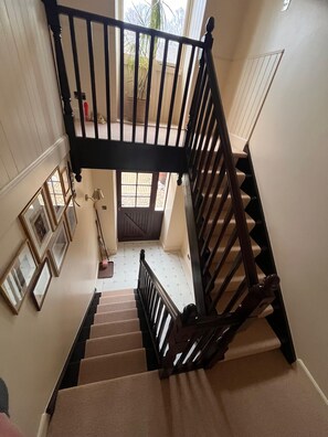 A staircase with a wooden handrail and beige carpeted steps leading to a landing. - The Hayloft at Brylach Steading, Speyside. (Aberlour)