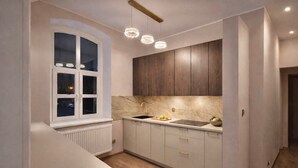Una cocina compacta con ventana, armarios de madera, una encimera y un lavamanos.