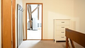 A room with a wooden door, a white dresser with three drawers, and a wooden bench. - Lake View Apartment, 2 min from Lake Constance. Balcony. Pets are welcome! (Ermatingen)