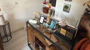 A modern interior with a wooden cabinet, a world map on the wall, and a shelf with books and decorative items.