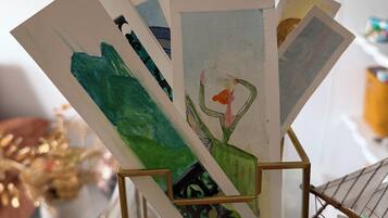 Un présentoir où sont exposées diverses œuvres d’art, dont un tableau représentant un cactus.