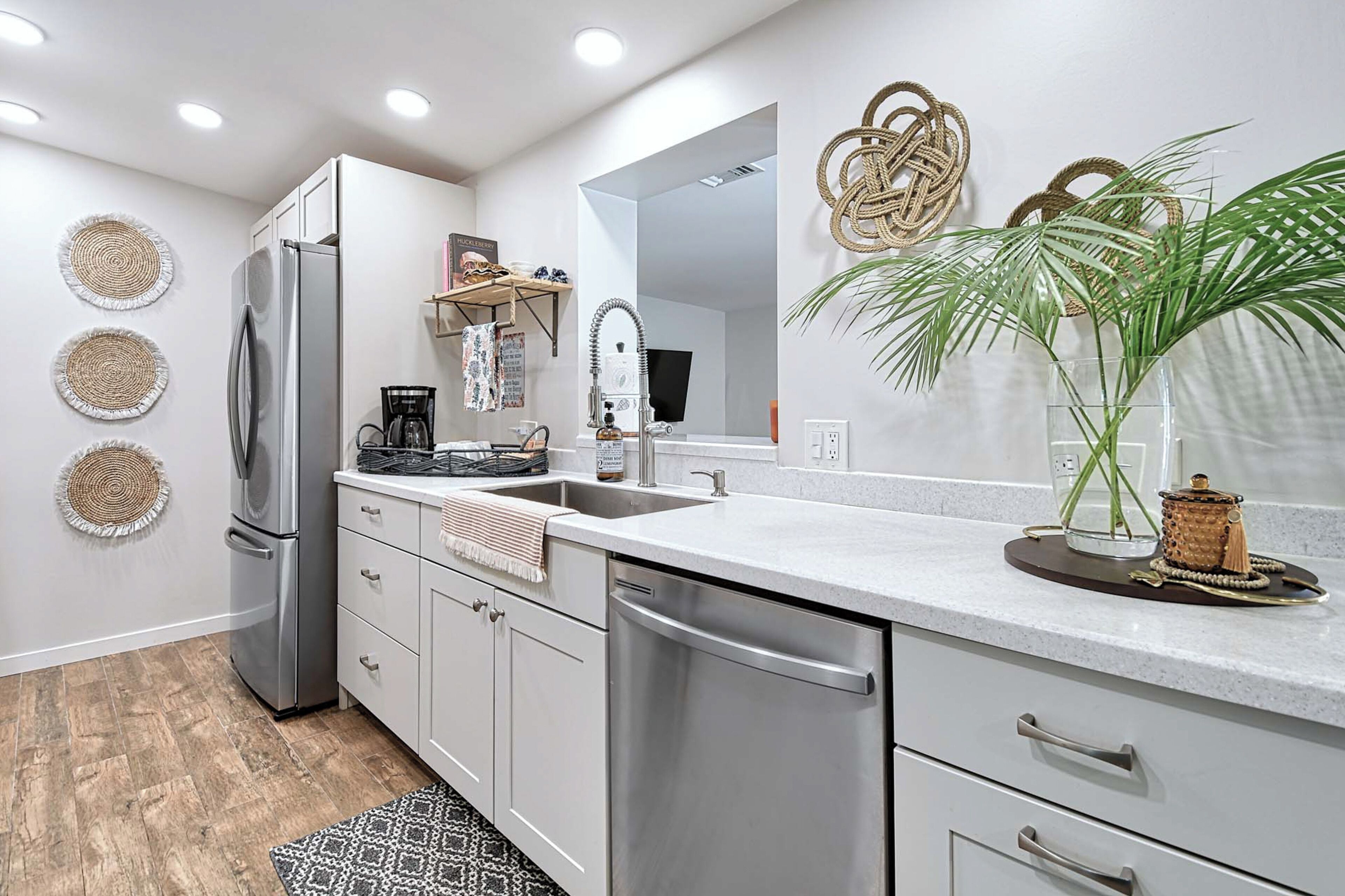 A modern kitchen with stainless steel appliances, a large island, and decorative wall art.