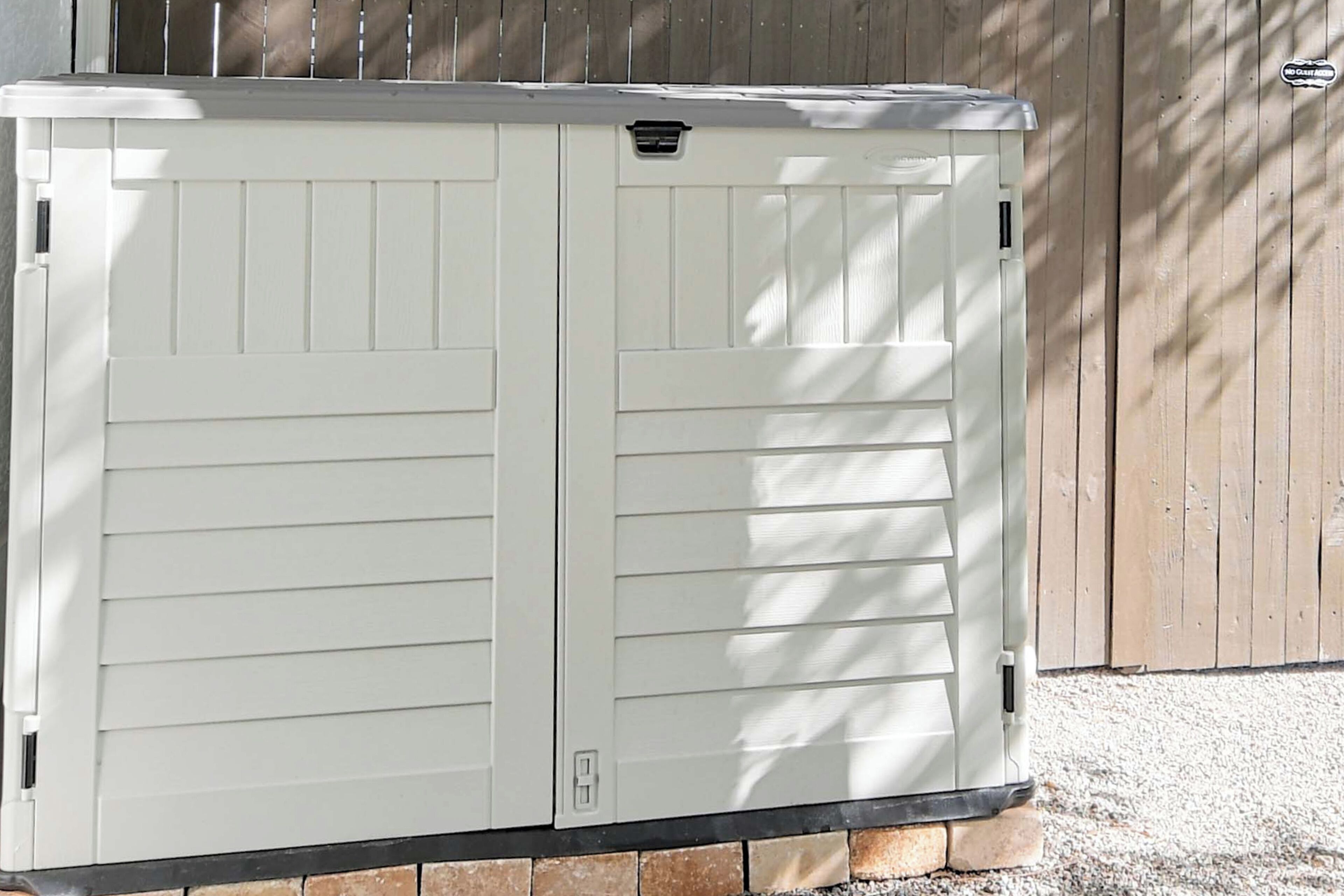 A white storage unit with two doors, a small ventilation slot, and a label on the top.