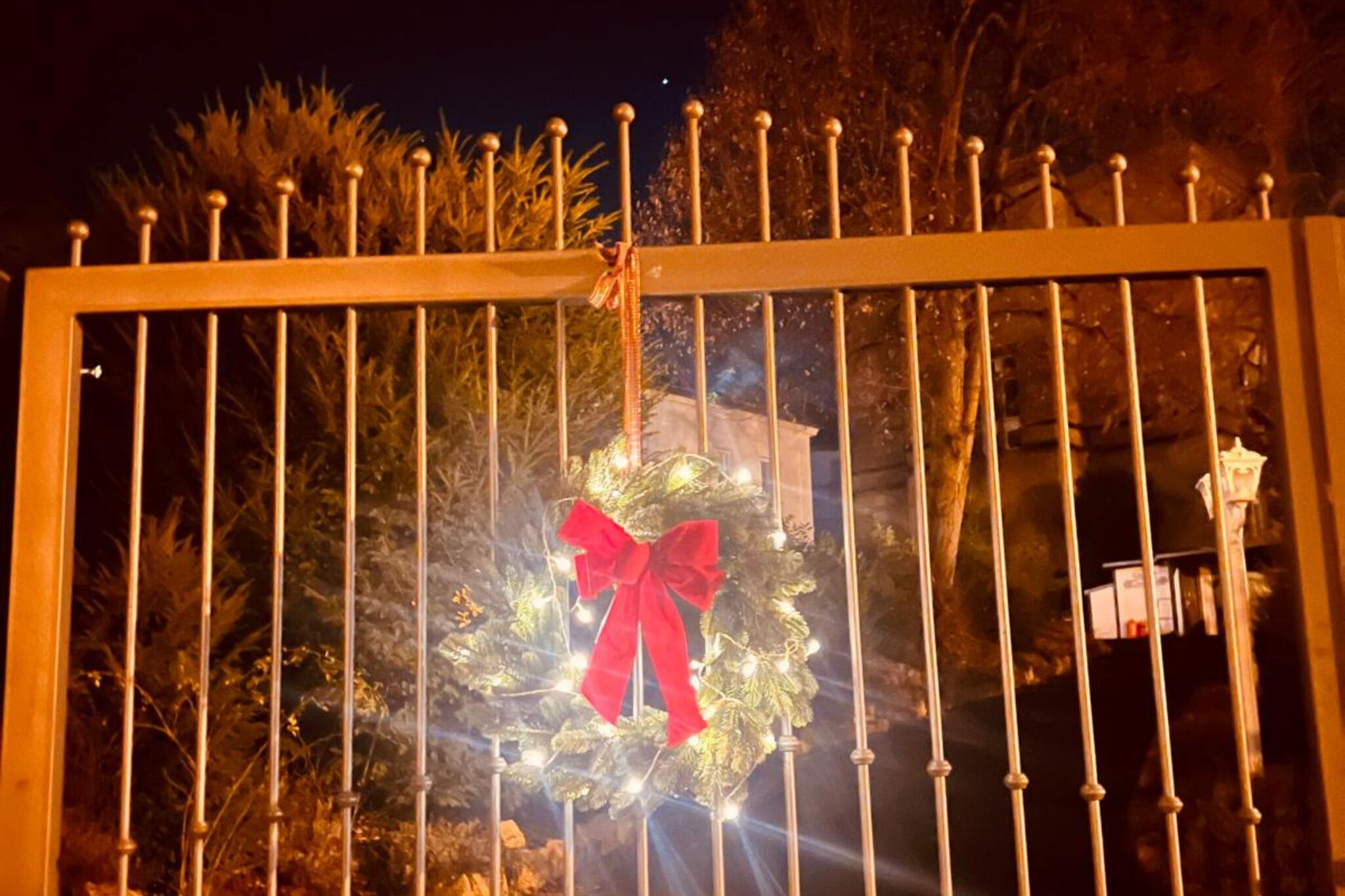 A gated area with a decorative wreath and a red bow.