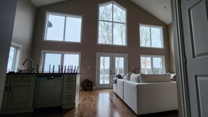Ein geräumiges Zimmer mit großem Fenster, einer Couch und einer Küchenzeile.
