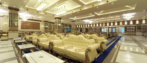 A luxurious hotel lobby with ornate chandeliers, plush seating, and a grand reception area.