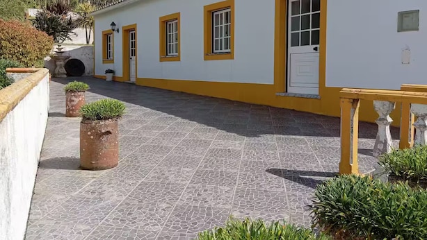 A building with yellow trim and a tiled courtyard.