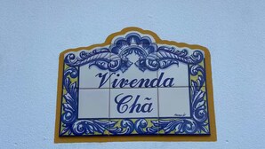 A decorative sign with the text "Vivenda Chá" on a light blue wall.