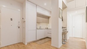 A modern kitchen with white cabinets, a built-in oven, and a small countertop. - Domus Appia by Rentbeat (Roma)