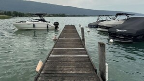 Un molo di legno si protende in acque calme, con due imbarcazioni ormeggiate al termine.