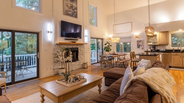 A spacious living room with a fireplace, a television, and a dining area. - Relaxing Beach Home Near Dunes & Downtown MC (Michigan City)