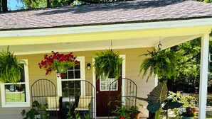 A covered porch with potted plants and a metal gate. - Cozy 1-bedroom studio in peaceful Historic Conway (Conway)