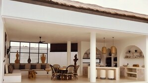 Un amplio salón con comedor, sofá y un ventanal grande.
