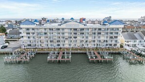 A multi-story hotel with balconies, a marina with docks, and a view of the sea. - Bahia Vista Unit 201 (Ocean City)