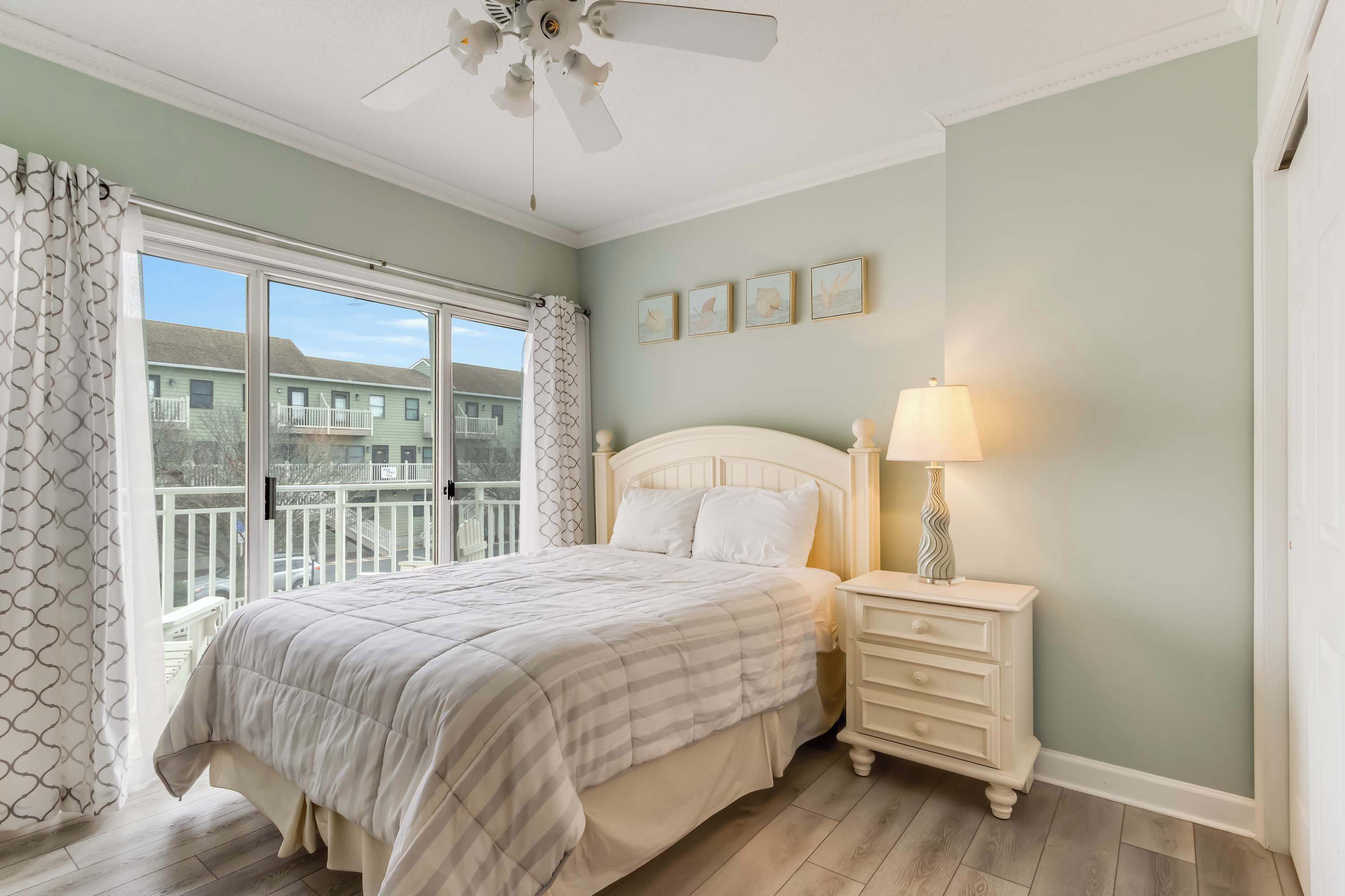 A bedroom with a bed, nightstand, and ceiling fan.