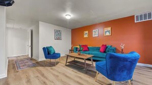 A living room with a sofa, two blue armchairs, a coffee table, and a patterned rug. - Cozy 2-BR Home w/ Parking & High-Speed Wi-Fi (Tucker)