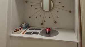 Ein weißer Schrank mit Spiegel und einer Sonnendesign-Wand.