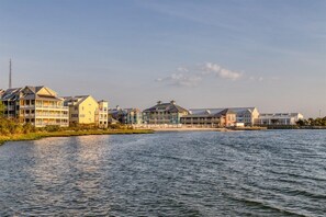 A waterfront hotel with multiple buildings, a dock, and a calm body of water. - Sunset Island 5 Beachside Mews (Ocean City)