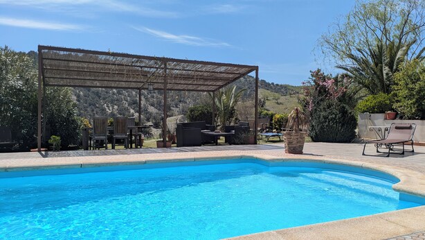 A swimming pool with a pergola, outdoor furniture, and a view of hills. - Coco Apart (Vélez-Rubio)