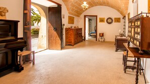 An interior with a piano, wooden furniture, a clock, and a sign indicating an exit. - Villa Moli dén Llull (Sant Llorenç Des Cardassar)