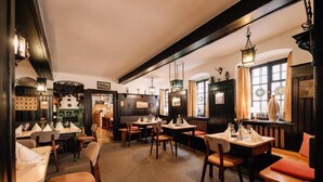 Ein Restaurant mit Holztischen, hängenden Laternen und einer gemütlichen Atmosphäre.