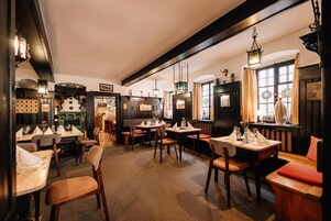 Restaurante com mobiliário de madeira, lanternas penduradas e um ambiente acolhedor.