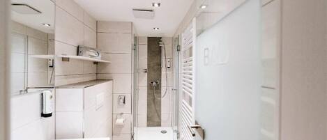 A modern bathroom with a toilet, sink, and shower area.