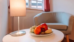 Ein runder, weißer Tisch mit einer Lampe und einer Obstplatte.