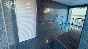 A tiled indoor pool area with a glass door, a metal railing, and a small seating area. - 2-bedroom apartment with air conditioning. (Foz do Iguaçu)