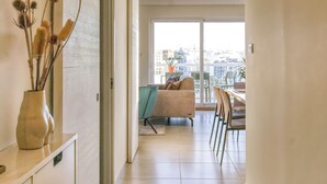 A modern interior with a hallway leading to a balcony with a city view. - Modern & Spacious 3BD Apt With Terrace (Msida)