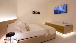 A modern bedroom with a bed, bedside table, and a mounted TV.