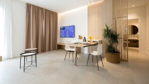 A modern dining area with a table, chairs, and a large plant.
