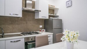 Eine moderne Küche mit Gasherd, Edelstahlgeräten und einer weißen Arbeitsplatte.