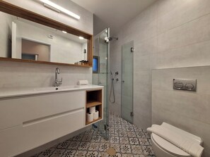 Eenvoudige tweepersoonskamer | Badkamer | Een douche, gratis toiletartikelen, een haardroger, handdoeken