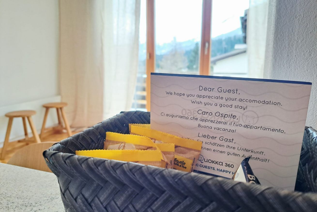 A welcome card in a wicker basket with a view of a cityscape through large windows.