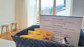 A welcome card in a wicker basket with a view of a cityscape through large windows.