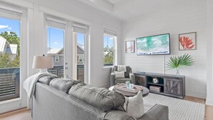 Ett modernt vardagsrum med en grå soffa, ett soffbord, en tv och en öppen spis.