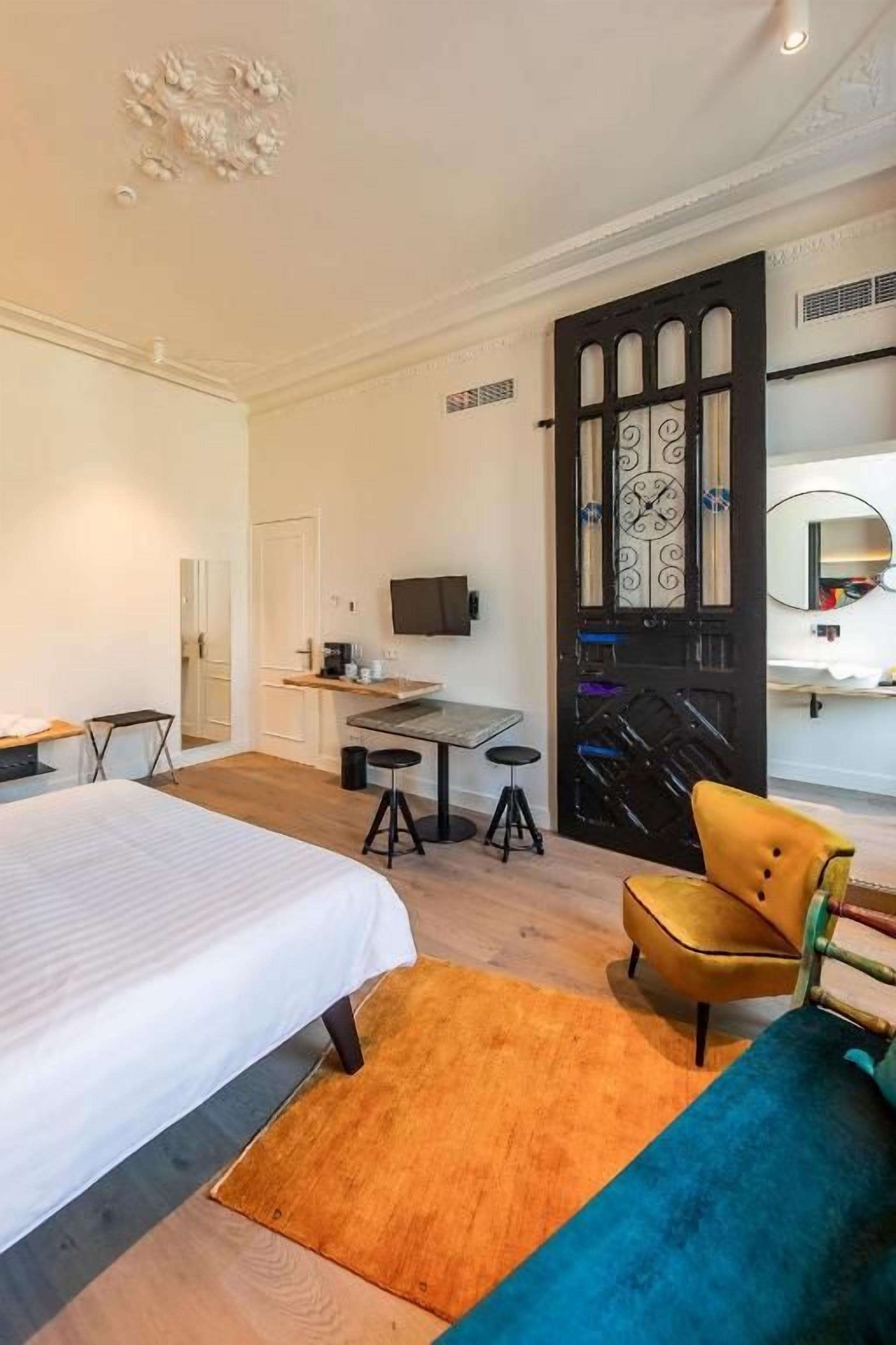 Una habitación de hotel con una cama, un escritorio, una silla y un televisor.