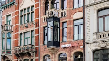 En rad historiska byggnader med distinkta arkitektoniska drag, inklusive en framträdande fasad av rött tegel och utsmyckade detaljer.