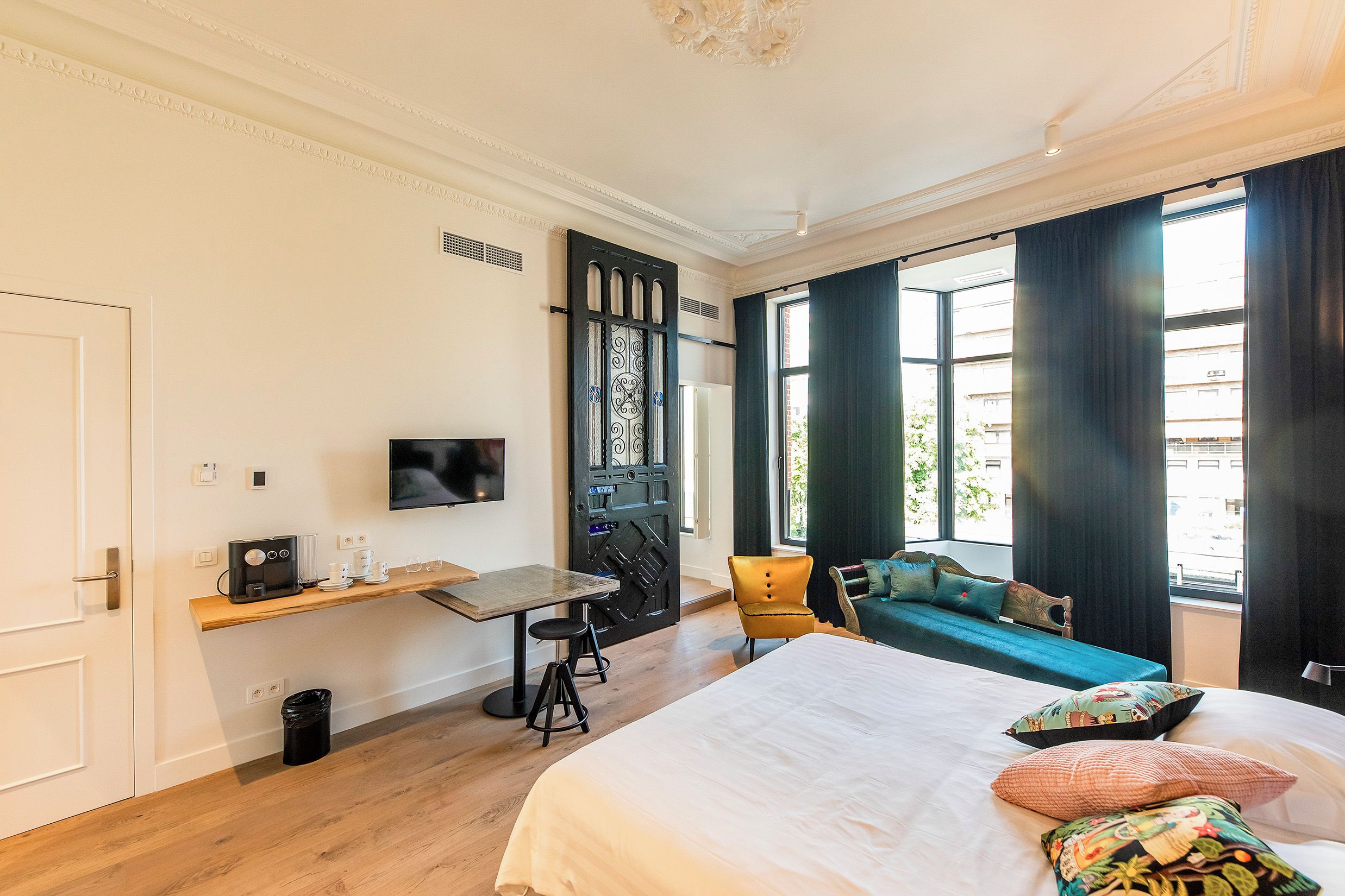 Een hotelkamer met een bed, een bureau met een televisie, een stoel en een bank.