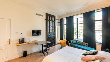 Een hotelkamer met een bed, een bureau met een televisie, een stoel en een bank.