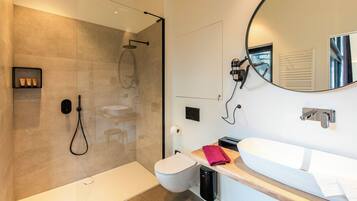 Een moderne badkamer met een douchecabine van glas, een wit wastafelmeubel en een grote spiegel.