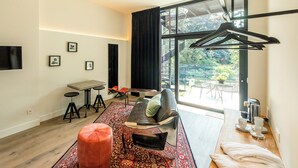 A modern living room with a sofa, ottoman, coffee table, and a dining area with chairs and a table. - Barefoodgiulia (Hasselt)
