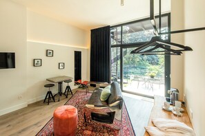 A modern living room with a sofa, ottoman, coffee table, and a dining area with chairs and a table. - Barefoodgiulia (Hasselt)