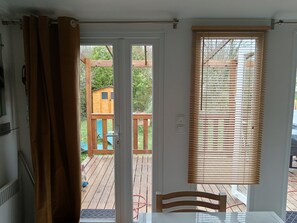 A room with a sliding glass door leading to an outdoor deck. - Mobile Home for 6 People - Sea & Nature - 3-star family-friendly and quiet campground - XXL campsite (Arces)