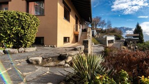 A building with a stone pathway, a stone staircase, and a view of mountains.
