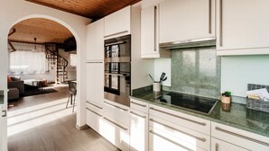 A modern kitchen with white cabinets, stainless steel appliances, and a green countertop.