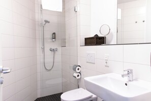 Een douche, handdoeken, zeep, shampoo