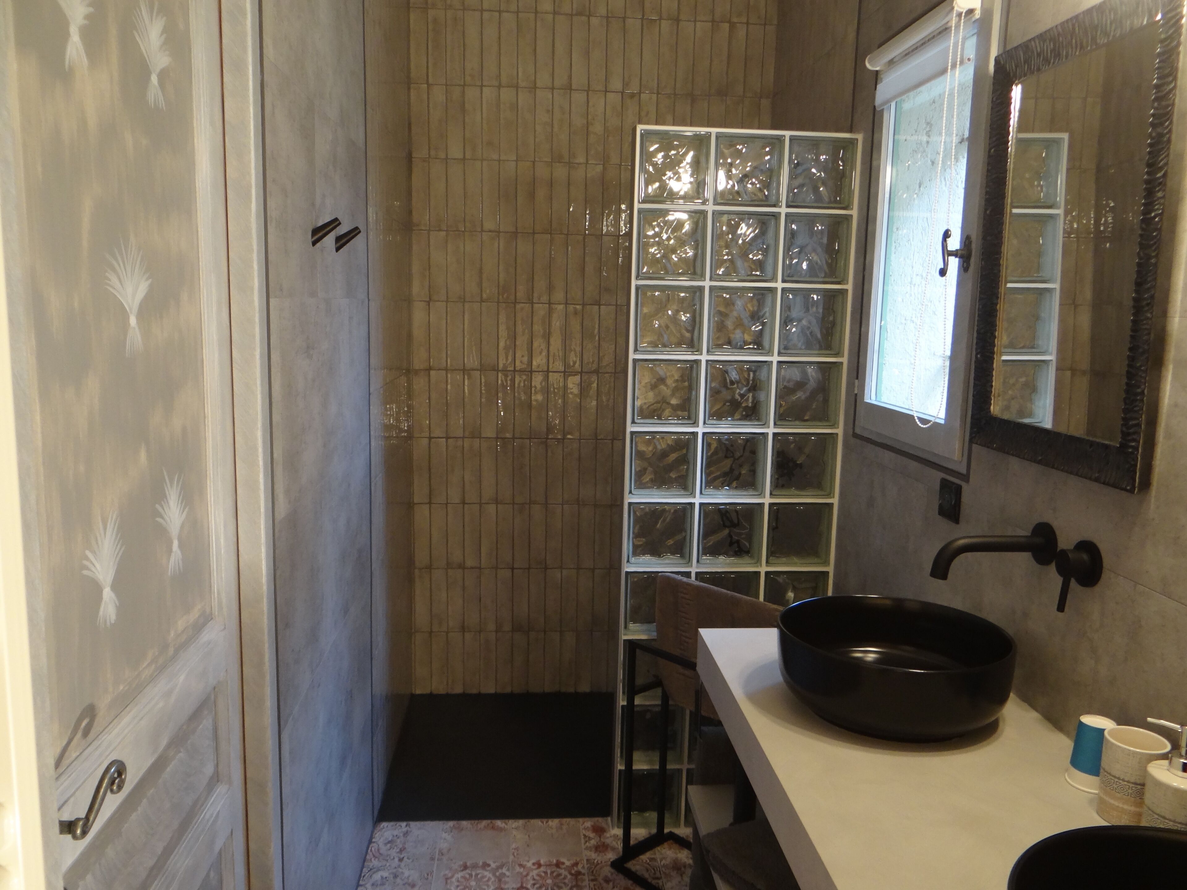 A bathroom with a shower, a sink, and a mirror.