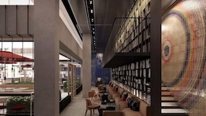 A modern library with bookshelves, a sofa, and a patterned wall. - Dizengoff 99 by Isrotel Design (Tel Aviv)